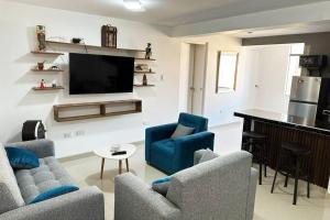 uma sala de estar com 2 cadeiras e uma televisão de ecrã plano em Morada Apartamentos em Tacna