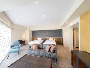 a hotel room with a bed and a couch at Loisir Hotel Kyoto Toji in Kyoto