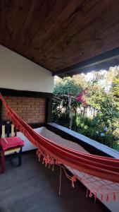 a hammock in a room with a bench and trees at Pousada Kokopelli in Lavras Novas