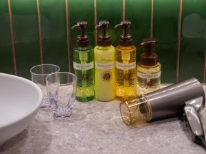 three bottles of soap and glasses on a counter at Loisir Hotel Kyoto Toji in Kyoto