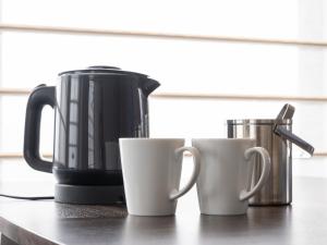 three coffee mugs sitting on a counter top at Loisir Hotel Kyoto Toji in Kyoto