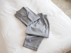 a pair of grey pants sitting on a bed at Loisir Hotel Kyoto Toji in Kyoto
