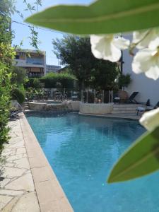 a swimming pool with blue water and white flowers at Hôtel La Villa Cannes in Cannes