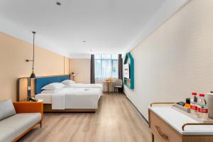una camera d'albergo con due letti e un divano di Guangzhou Yilin Hotel - Xiaogang metro Store a Canton