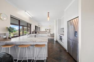 a kitchen with a large island with stools at Sea Breeze - Spacious home with lovely ocean views in Port Elliot