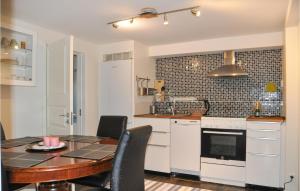 cocina y comedor con mesa y sillas en Pet Friendly Apartment In Myggens With Kitchen en Myggenäs