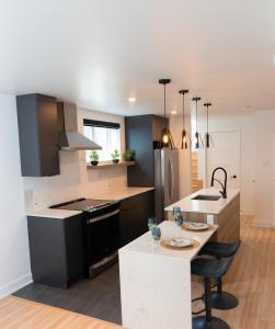 a kitchen with black and white appliances and a table at Bienvenue chez vous! in Pointe-Calumet