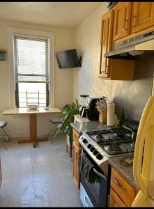 a kitchen with a stove and a table in it at Woodside, queens in Woodside
