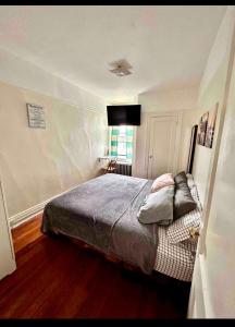 a bedroom with a bed and a television on the wall at Woodside, queens in Woodside