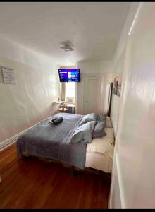 a bedroom with a bed with a tv on the wall at Woodside, queens in Woodside