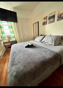 a bedroom with a bed with a hat on it at Woodside, queens in Woodside