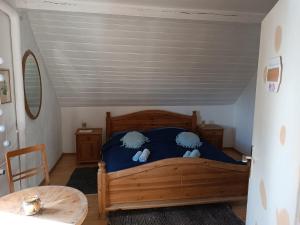 una camera con letto in legno e cuscini blu di Zimmer Veljanovski a Blaufelden