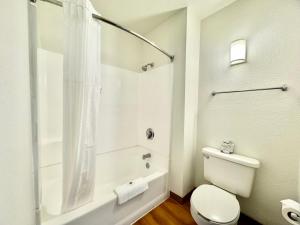 a white bathroom with a toilet and a shower at Studio 6 Bellflower CA Los Angeles in Bellflower +19 photos
