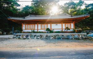 an asian style building with the sun in the background at Doyosae Hanok Pension in Suncheon
