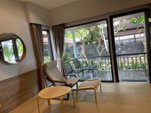 salon z krzesłem, stołem i oknami w obiekcie Evergreen Resort w mieście Chaweng