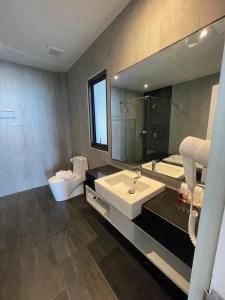 a bathroom with a sink and a toilet and a mirror at Evergreen Resort in Chaweng