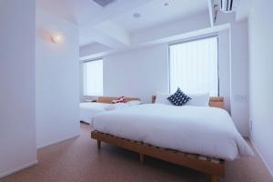 a bedroom with two beds and a large window at KABIN Minamiza in Kyoto