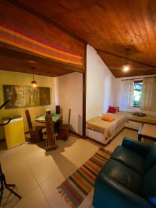 a living room with a bed and a dining room at Pousada Kokopelli in Lavras Novas