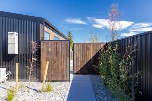 a modern house with a black fence and a walkway at Ben Ohau Views The Studio in Twizel