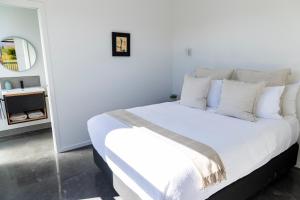 Dormitorio blanco con cama con sábanas y almohadas blancas en Ben Ohau Views The Studio en Twizel