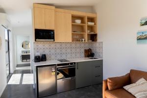 a kitchen with a stove top oven next to a couch at Ben Ohau Views The Studio in Twizel