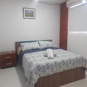 een slaapkamer met een bed met een deken en een nachtkastje bij MALALA3 depa amoblado in Sincelejo
