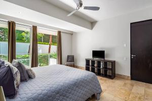 a bedroom with a bed and a tv and a window at Amapas ocean view condo in Puerto Vallarta +37 photos
