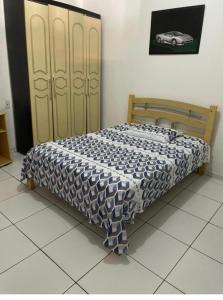 Bett mit blauer und weißer Decke in einem Zimmer in der Unterkunft Casinha da vovó in Tutóia