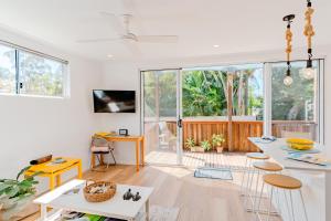 a white living room with a table and chairs at Private and peaceful house near the Beach in Coolum Beach