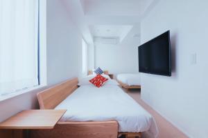 a room with a bed and a flat screen tv at KABIN Minamiza in Kyoto