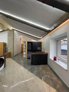 eine große Küche mit einer Theke und einem Fenster in der Unterkunft Lauku rezidence in Cēsis