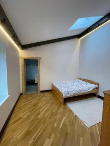 ein Zimmer mit einem Bett in der Ecke eines Zimmers in der Unterkunft Lauku rezidence in Cēsis