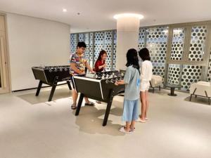 a group of people playing ping pong in a room at The Song Luxury Apartment by Lisa House in Vung Tau