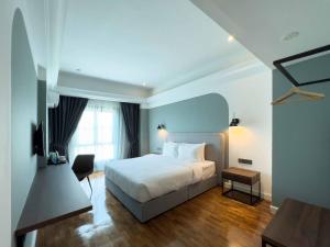 sypialnia z białym łóżkiem i oknem w obiekcie Hotel Seri Costa w Malakce