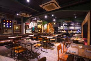 a restaurant with tables and chairs and a bar at THE 1O1 Bali Fontana Seminyak in Legian