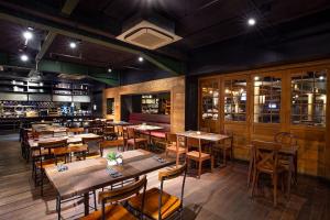 a restaurant with tables and chairs and a bar at THE 1O1 Bali Fontana Seminyak in Legian