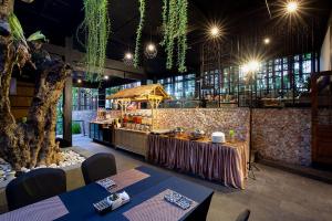 a restaurant with two tables and a counter in a room at THE 1O1 Bali Fontana Seminyak in Legian