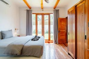 a bedroom with a bed and a large window at Villa Markisa - luxury private pool villa Gili Air in Gili Air