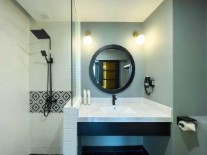 W łazience znajduje się umywalka i lustro. w obiekcie Hotel Seri Costa w Malakce