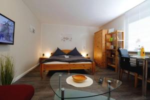 Schlafzimmer mit einem Bett und einem Glastisch in der Unterkunft Ferienwohnung Düneneck 14 Gartenhaus in Sankt Peter-Ording