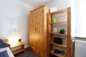 Zimmer mit einem Holzbuchregal und einem TV in der Unterkunft Ferienwohnung Düneneck 14 Gartenhaus in Sankt Peter-Ording