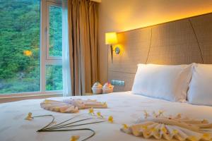Una habitación de hotel con una cama con toallas. en Ocean View Resort Yalong Bay, en Sanya