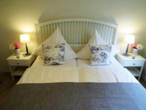 グリュックスブルクにあるFerienwohnung Angelnのベッドルーム1室(白いベッド1台、枕、ランプ2つ付)