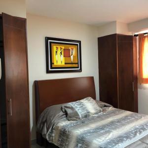 - une chambre avec un lit et une photo sur le mur dans l'établissement Amplio departamento en Marina, à Mazatlán