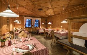 a dining room with tables and chairs and lights at Hotel Kreuzberg Monte Croce in Sesto