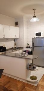 une cuisine avec des armoires blanches et un comptoir dans l'établissement French I Recoleta, à Buenos Aires 3 autres photos