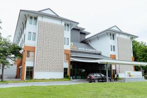 a building with a car parked in front of it at RUS Hotel&Convention Ayutthaya in Phra Nakhon Si Ayutthaya