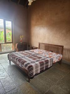 a bedroom with a bed with a blanket on it at Serene meadows villa in Bangalore