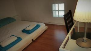 a bedroom with a bed with a lamp and a window at Superior Motel l in Haifa
