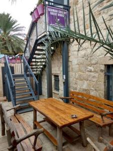 een houten bank en een tafel voor een gebouw bij Superior Motel l in Haifa